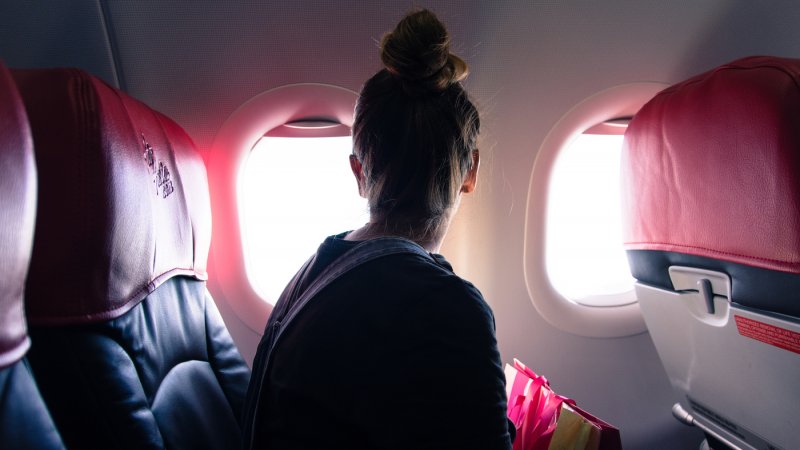 Mulher olhando janela de avião